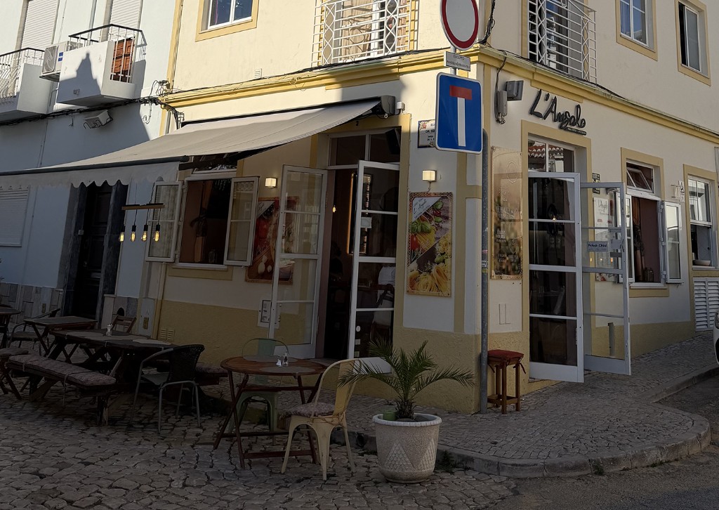 Exterior of L'Angolo Trattoria Pizzeria on a street corner in Alvor, Portugal